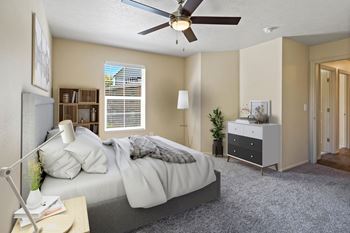 A bedroom with a bed, nightstand, and a ceiling fan.